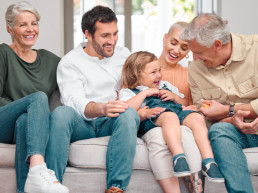 Grandpa brings the giggles. Shot of a happy family bonding on the sofa at home